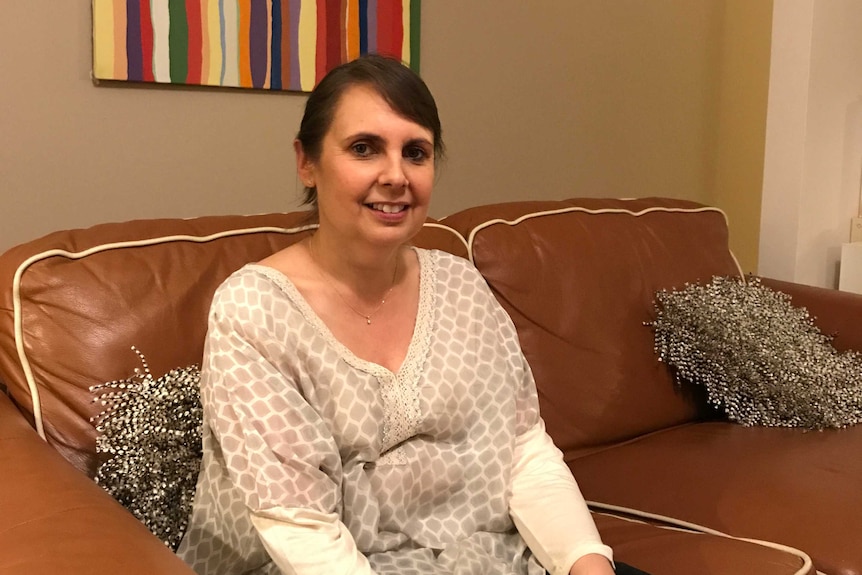 Nurse Fiona Ashworth sits on a couch at her Mandurah home.