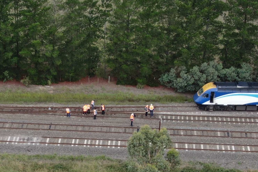An aerial photograph shows the final carriage in the derailed train a short distance from a fork in the train tracks.
