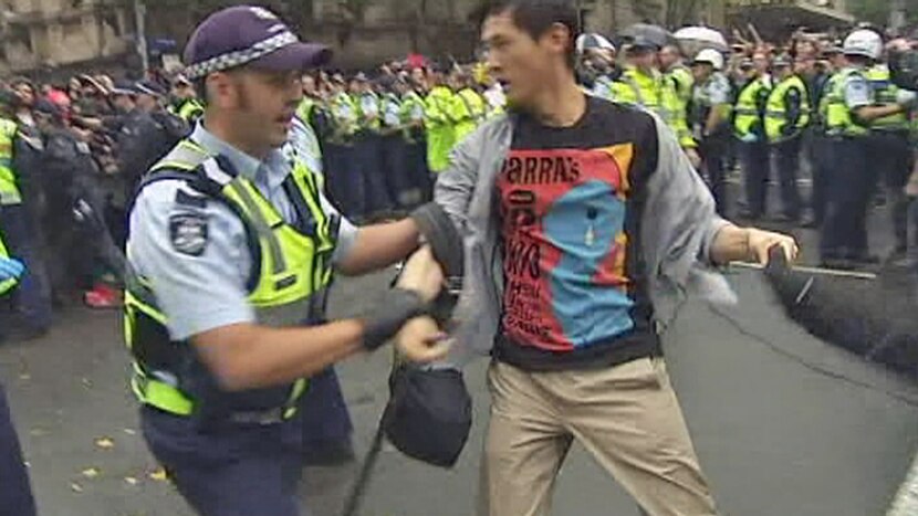 Protester is led away by a police officer during 'Occupy' demonstration in Melbourne