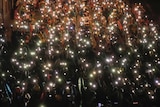 Pro-democracy protesters shine their mobile phone lights during an anti-government protest at Victory Monument in Bangkok.