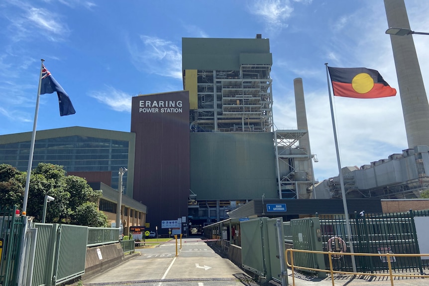 A power station with flags flying in front.