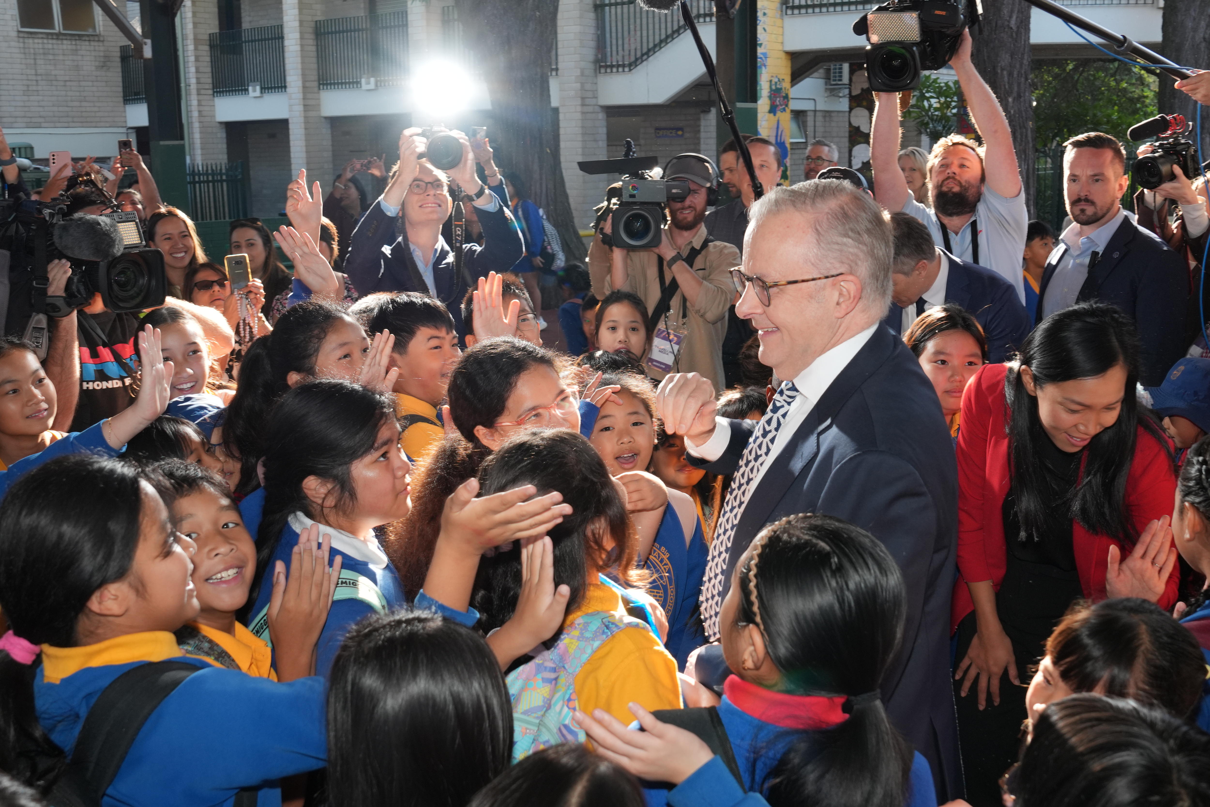 PM lifts a child in his arms at a primary school