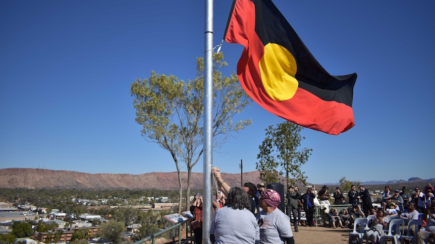 Aboriginal flag being raised at the start of NAIDOC Week on Anzac Hill in Alice Springs