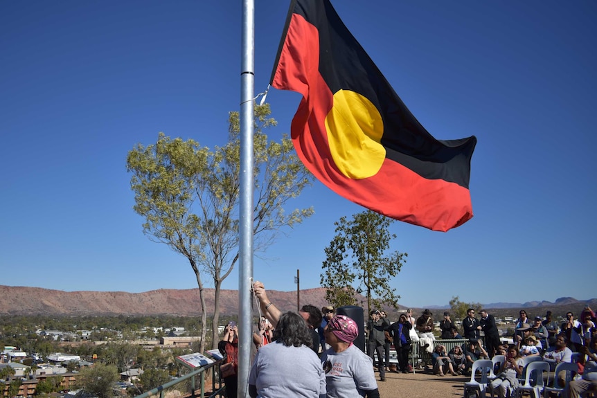 Aboriginal flag being raised at the start of NAIDOC Week on Anzac Hill in Alice Springs