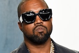 Kanye West looks serious in sunglasses at event 