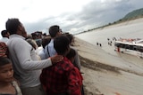 Grim scenes ... onlookers watch on as rescuers search for the crash victims.