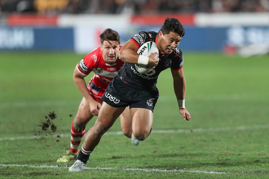 Mason Lino of the Warriors beats Gareth Widdop of the Dragons to score a try in Auckland.