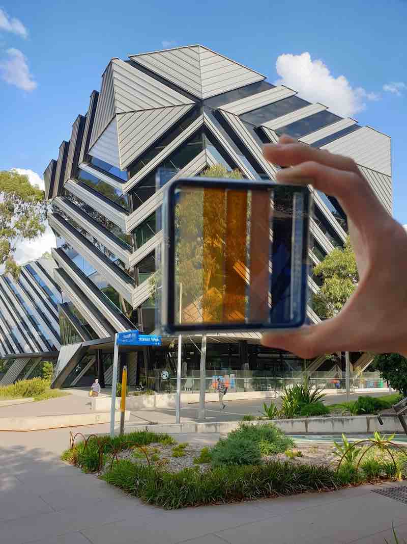 A semi-transparent square of glass held in front of a glass building