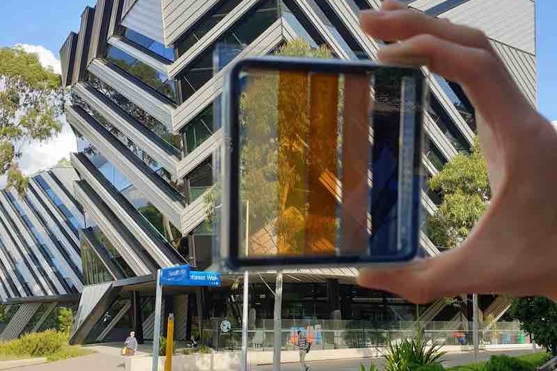 A semi-transparent square of glass held in front of a glass building