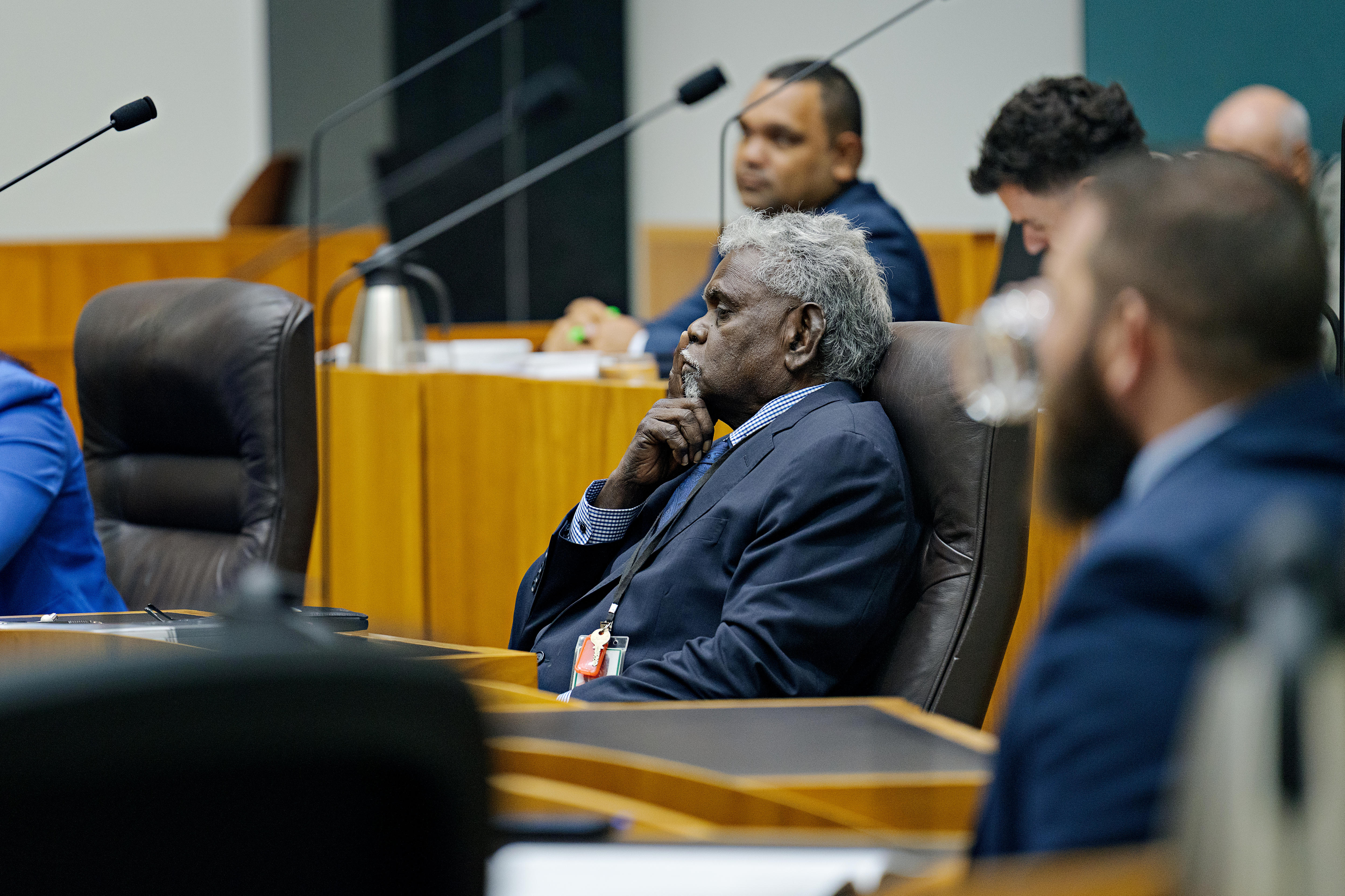 Un hombre con traje oscuro se sienta en el Parlamento del NT.