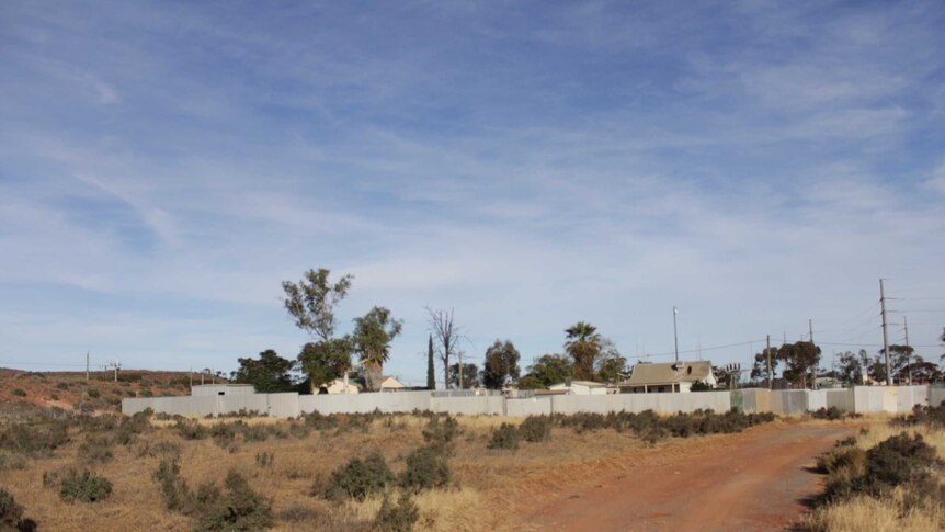 Image of waste ground and the rear of residential properties in Boulder, Western Australia.