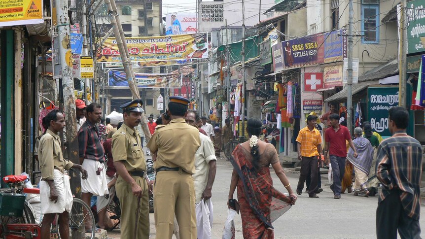 People walk along a shopping street in Thiruvananthapuram.