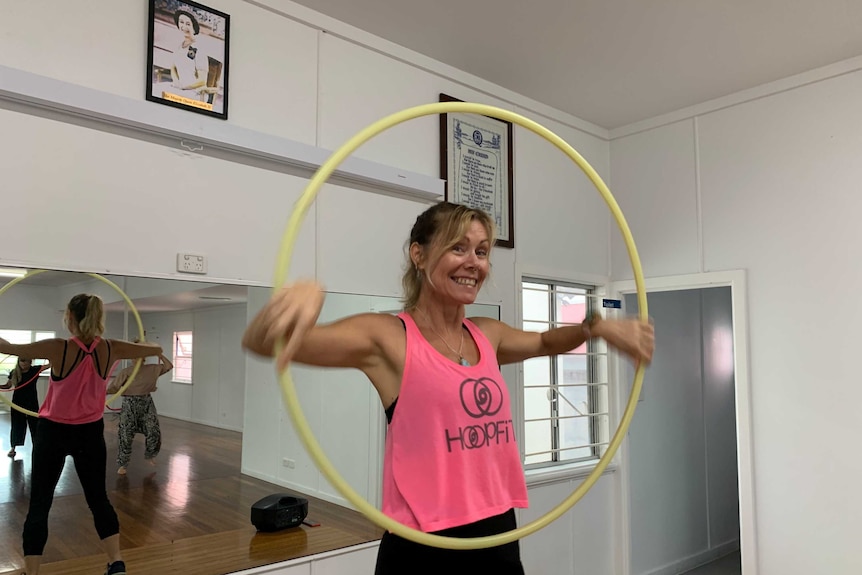 old photo of the Queen on CWA hall wall as instructor leads hula hoop class