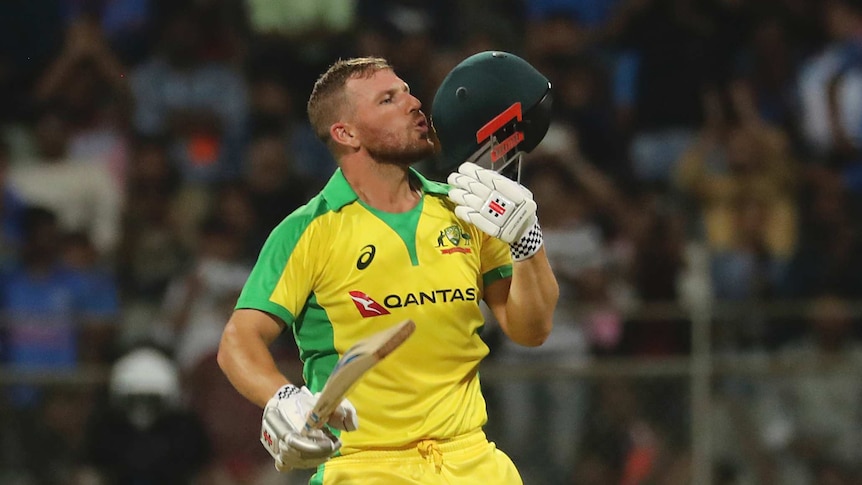 Aaron Finch kisses the badge on the front of his helmet