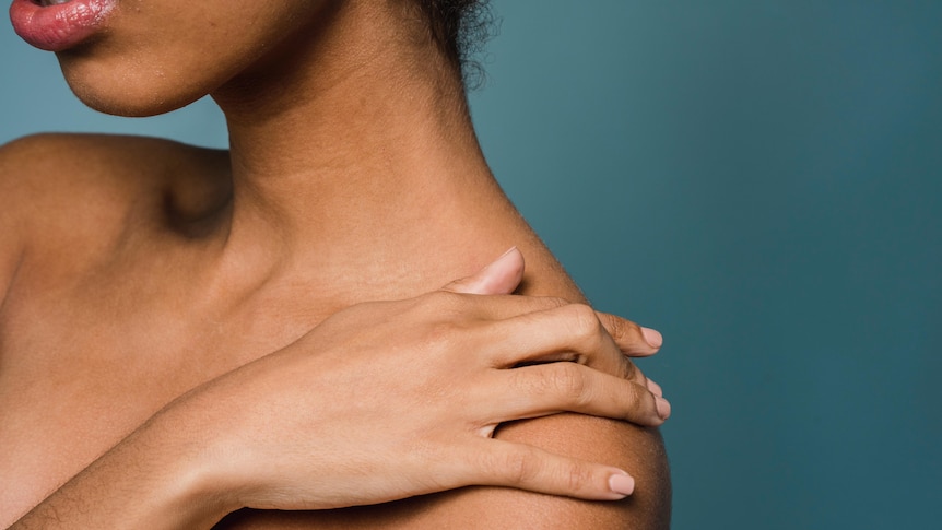 Close-up of woman touching her shoulder, in a story about women who have difficulty reaching orgasm and the causes.