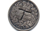 The coin with the letter T engraved on it.