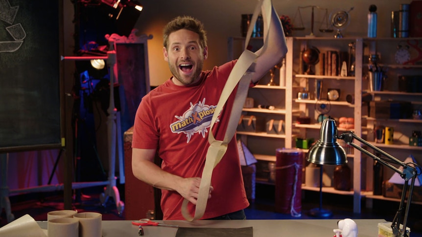 Man looks amazed and holds large chain of interlocking loops of paper