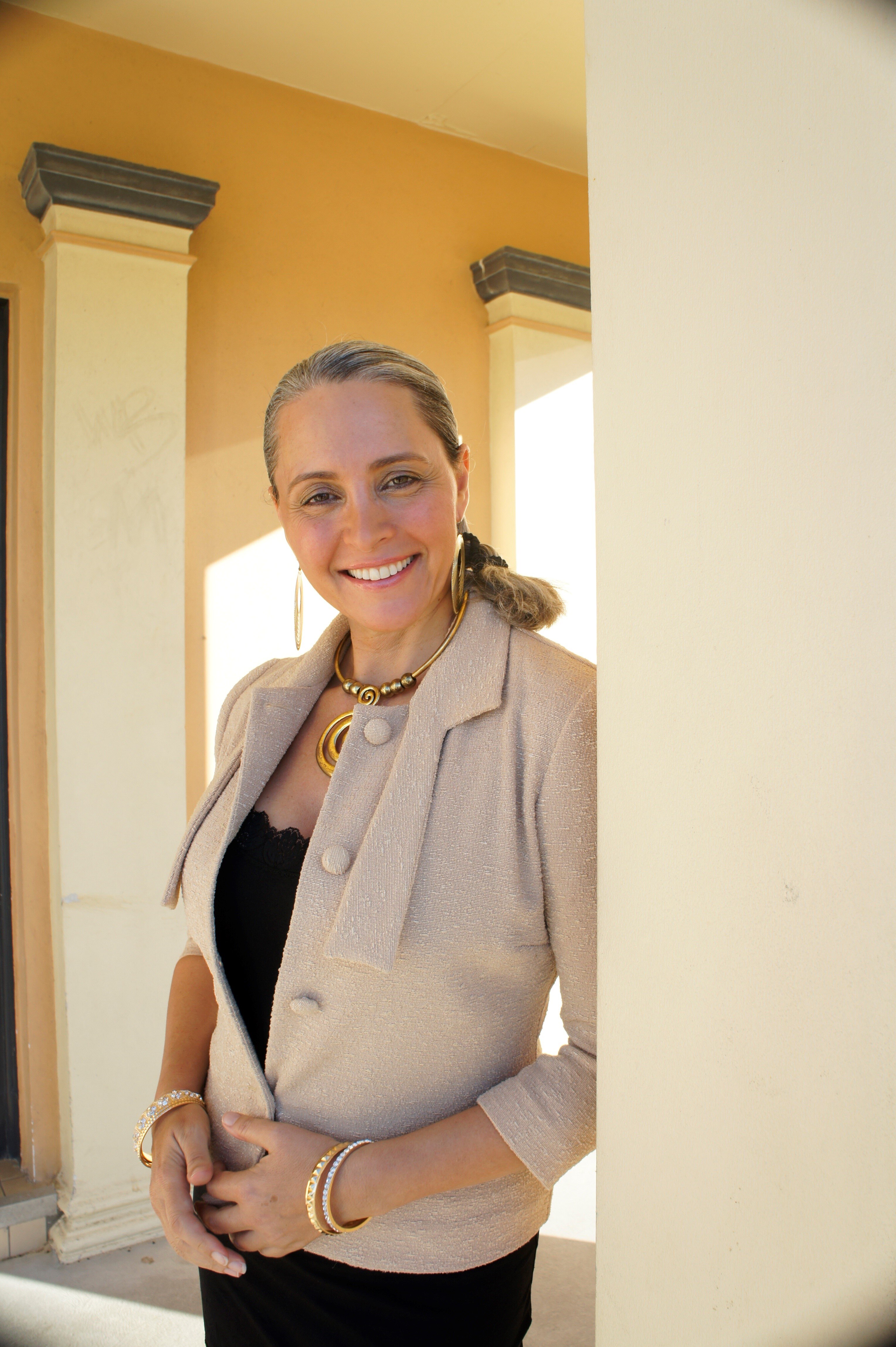 A woman smiling standing in a doorway