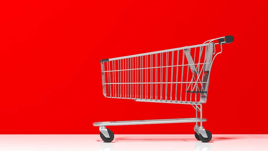 A metal shopping trolley against a red background.