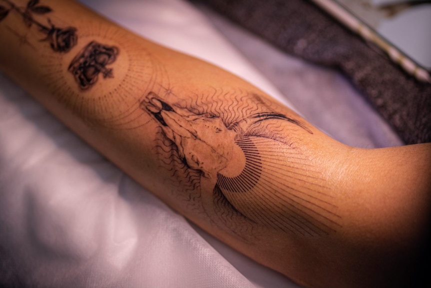 A man's arm with a cattle skull tattoo on it 