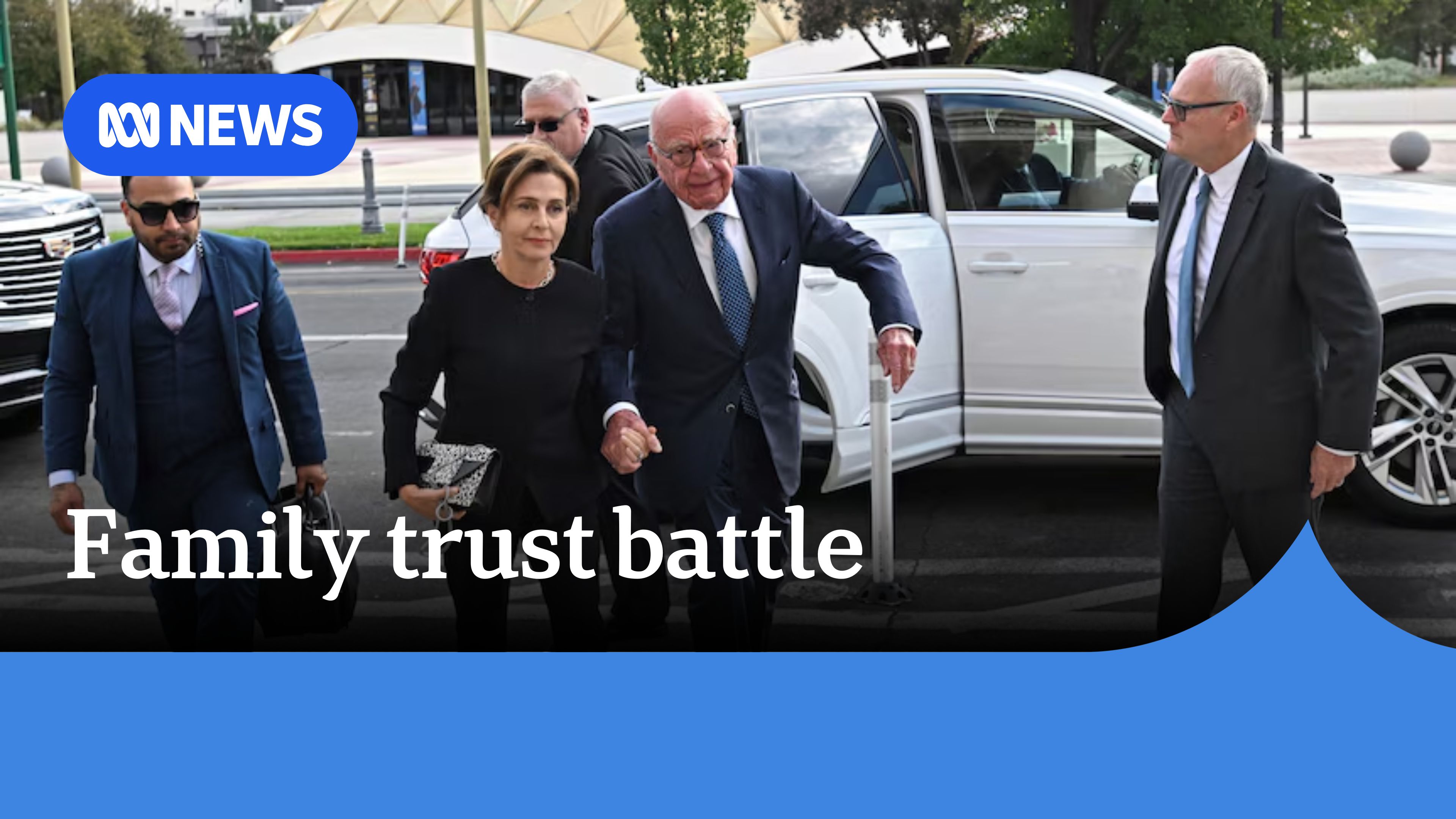 Family trust battle: Rupert Murdoch walking on a footpath with a white car's open passenger door behind him.
