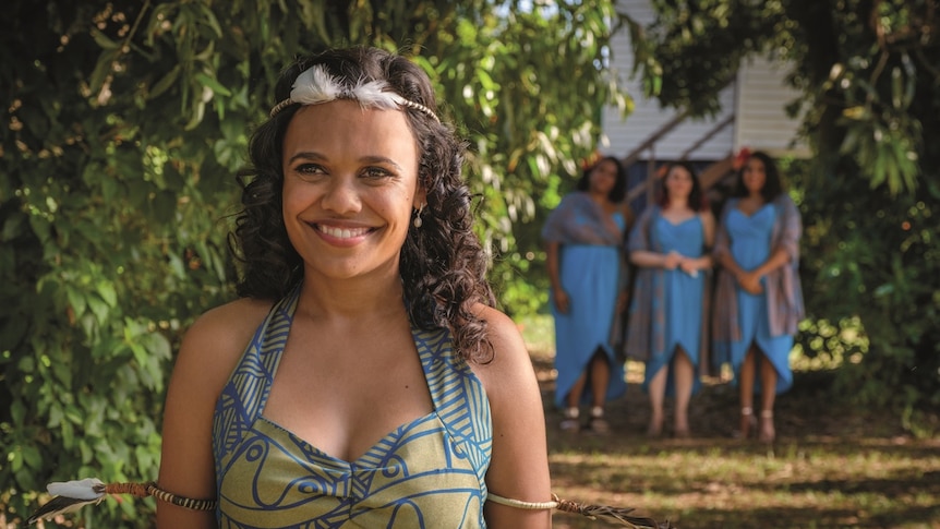 Miranda Tapsell smiles as she wears a colourful wedding dress.