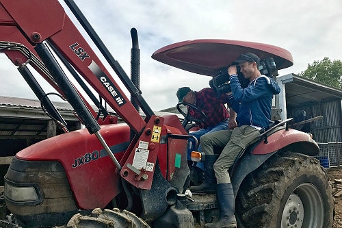Camera operator Matt Roberts shooting a flood affected farm from atop a tractor near Murwillumbah.