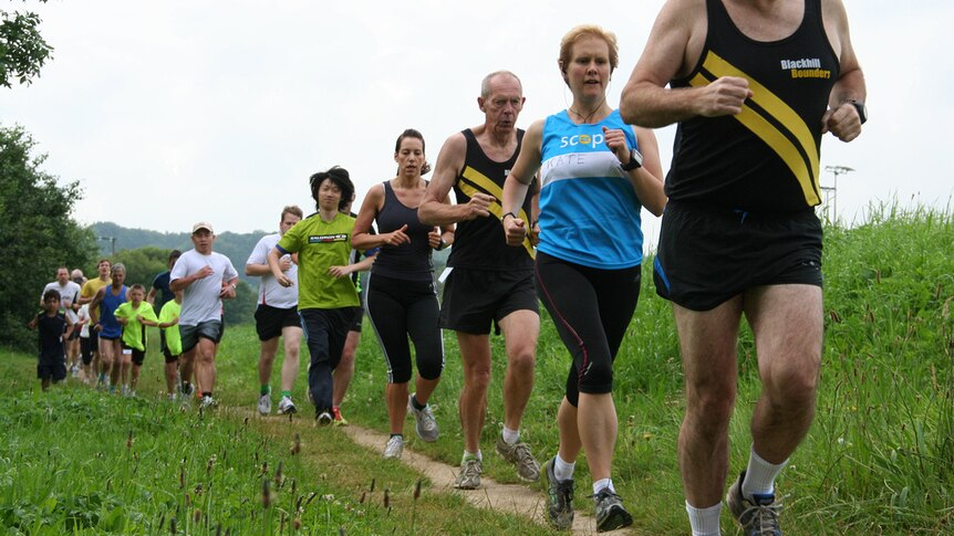 People of various ages run down a track in a line