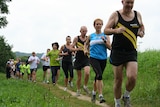 People of various ages run down a track in a line