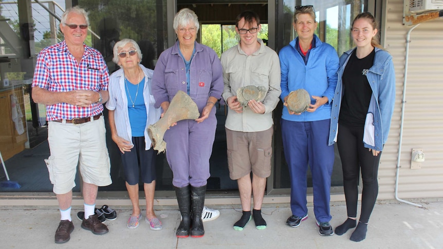 The group of four citizen scientists stand with Dr Kemper in the middle, holding bones of various sizes.