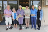 The group of four citizen scientists stand with Dr Kemper in the middle, holding bones of various sizes.