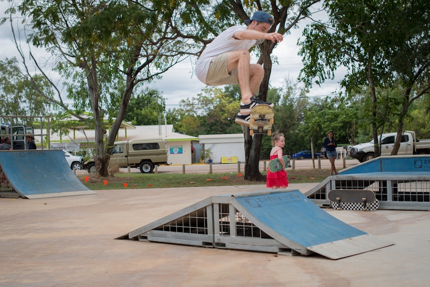 A skateboarder performs an 'ollie' - a trick where the rider and board are both lifted high in the air - off a ramp.