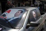 Election posters are displayed on a car in the Syrian city of Latakia