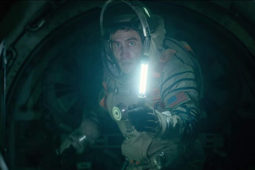 Jake Gyllenhaal holds a light on the International Space Station in a scene from the film Life.
