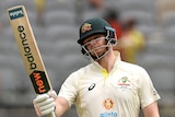 Australia batter Steve Smith holds up his bat as teammate Travis Head stands behind him during a Test against West Indies.