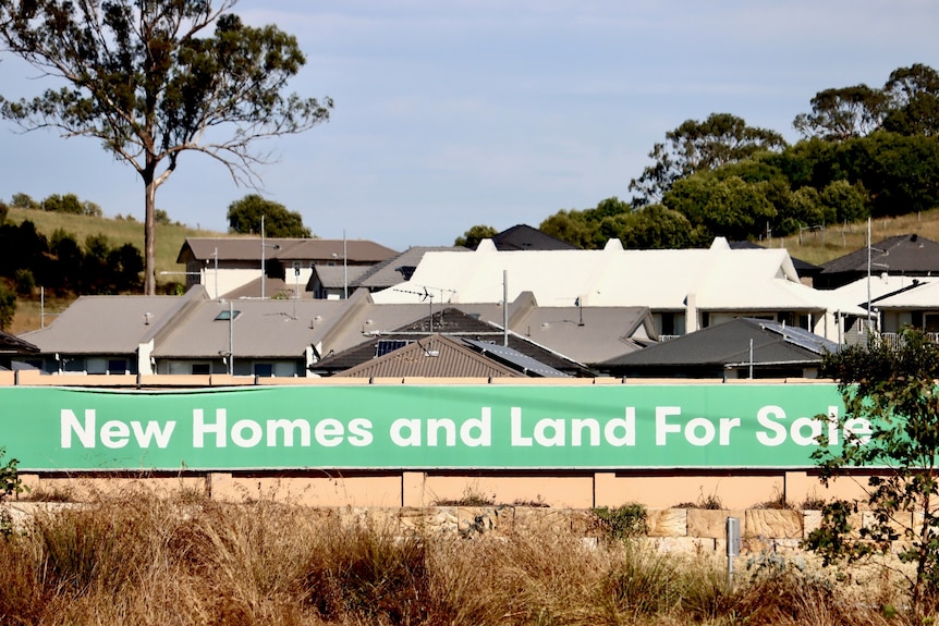 a sign in an empty lot saying for sale