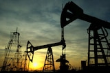 Oil derricks are silhouetted against the rising sun at an oilfield in the Azerbaijan capital Baku.