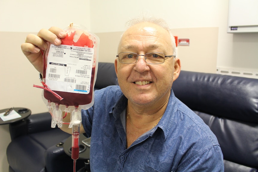 Man holds up pack of blood