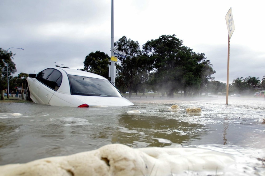 A car sinks into water on Forrest Hill Road.