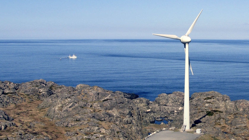 A windmill stands next to the ocean in Utsira, a North Sea island.