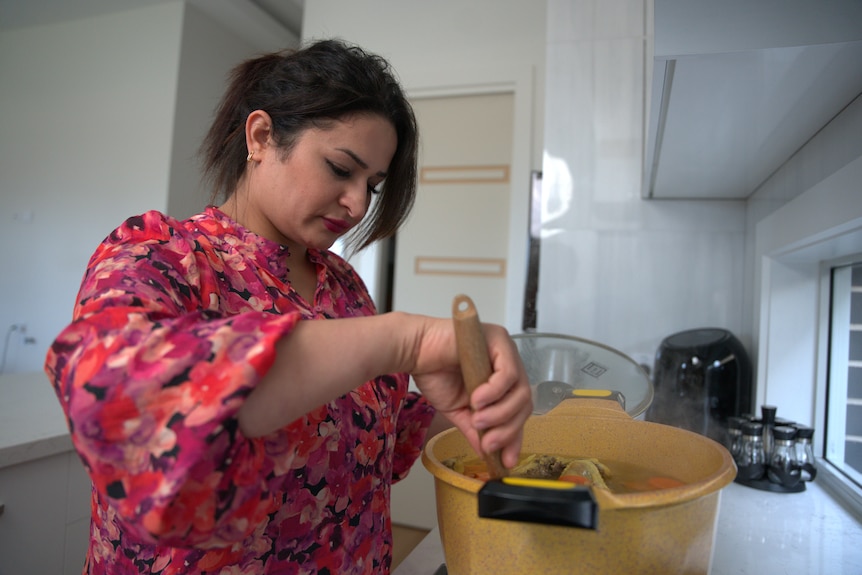 A woman stirring a pot in a kitchen