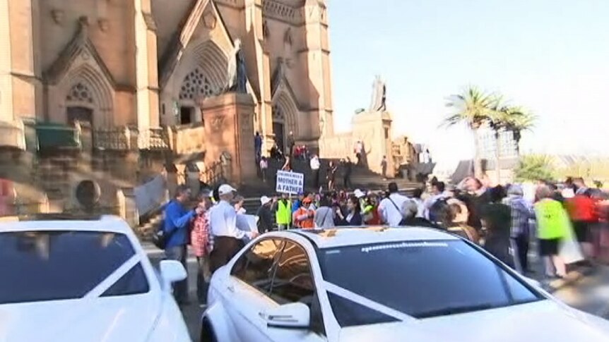A large crowd of people outside a cathedral