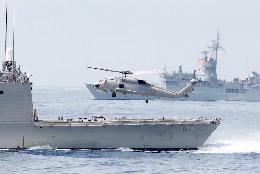 浅灰色的直升机从军舰上起飞