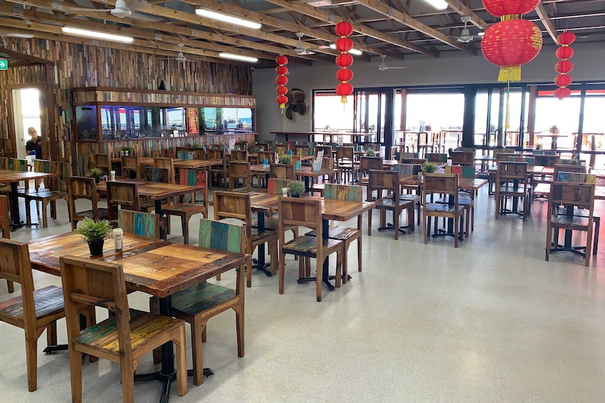 The inside of a restaurant with rows of empty tables.