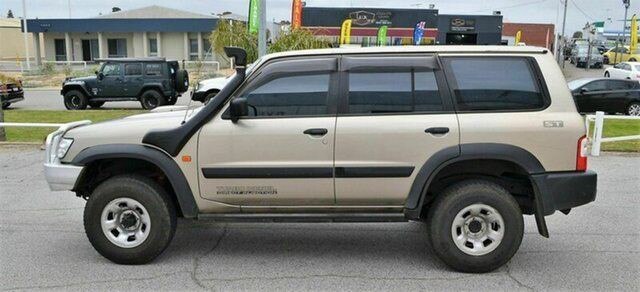A gold-coloured four-wheel-drive vehicle parked on a road.