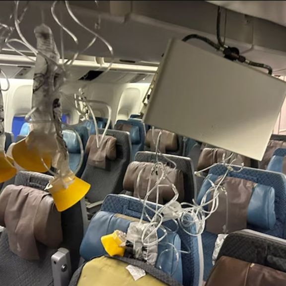 The inside of an empty airplane with oxygen masks hanging from the cabin