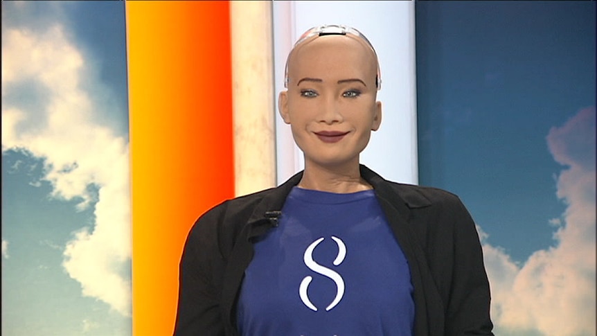 The torso of Sophia the robot sits at the news desk.