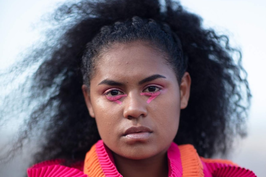 A young indigenous model wears a contemporary looking dress made with traditional weaving practices