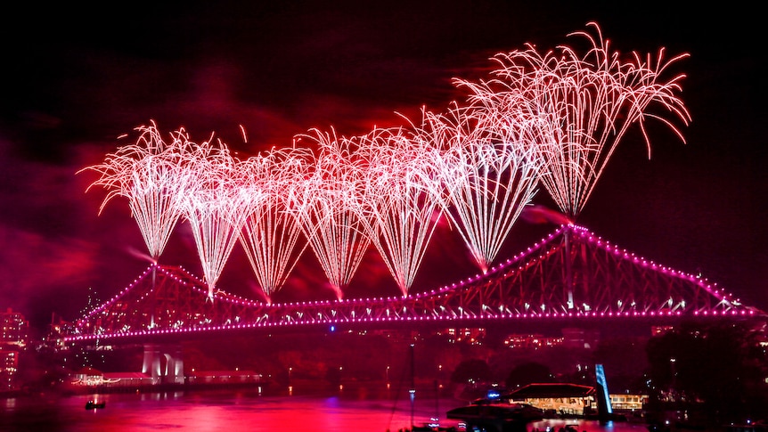 Red fireworks off bridge over river