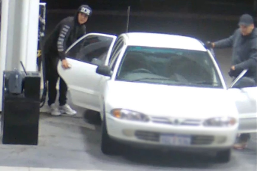 CCTV footage shows two men stepping out of a white sedan at a petrol station.